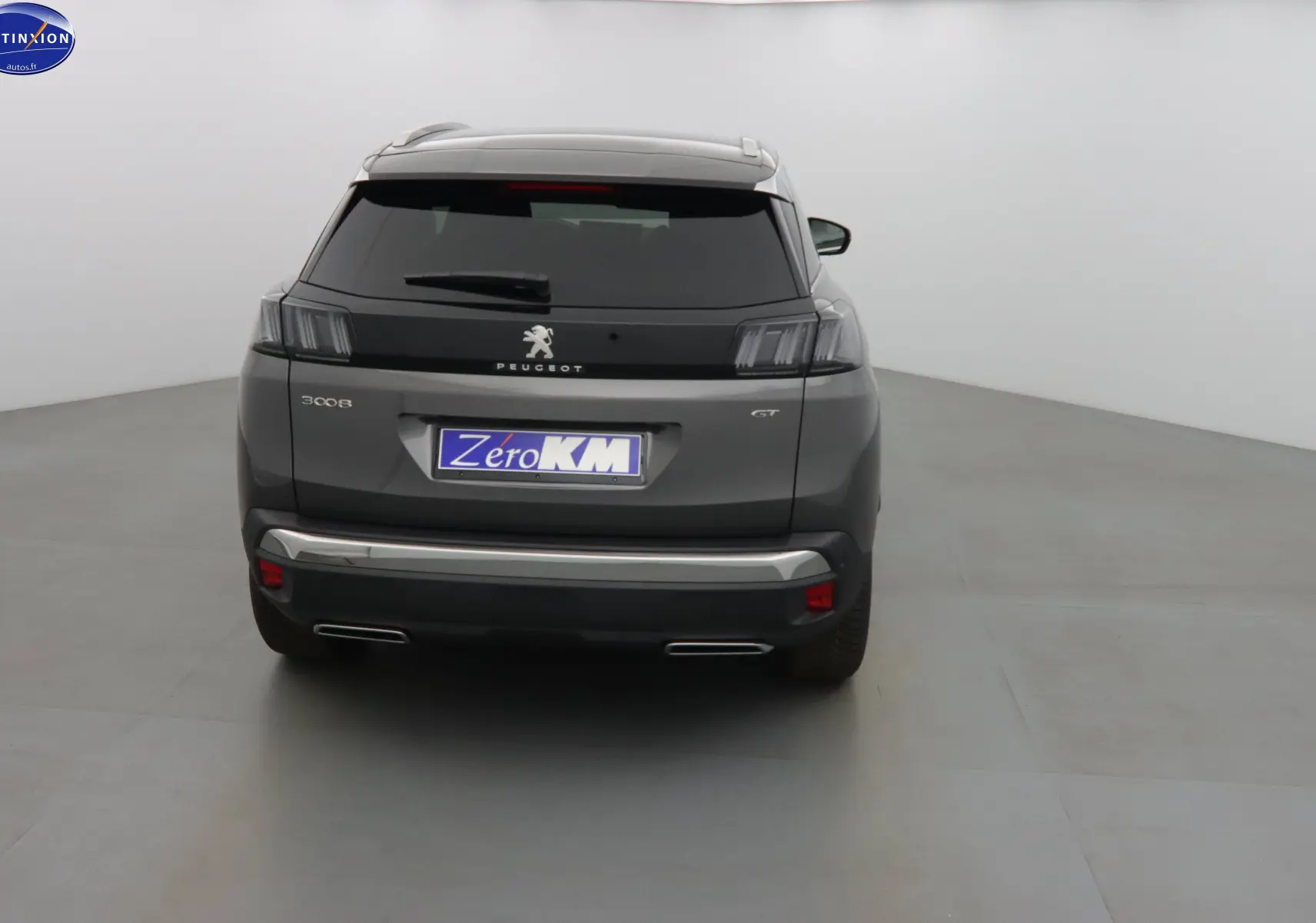 Vue arrière d'un Peugeot 3008 gris platinium métal avec feux arrière à effet tridimensionnel et double sortie d'échappement.