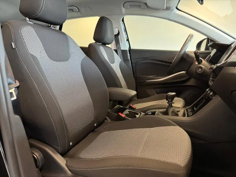 Vue intérieure côté gauche de l'Opel Grandland 2023, sièges tissu Berson noir avec console centrale et volant cuir sport.