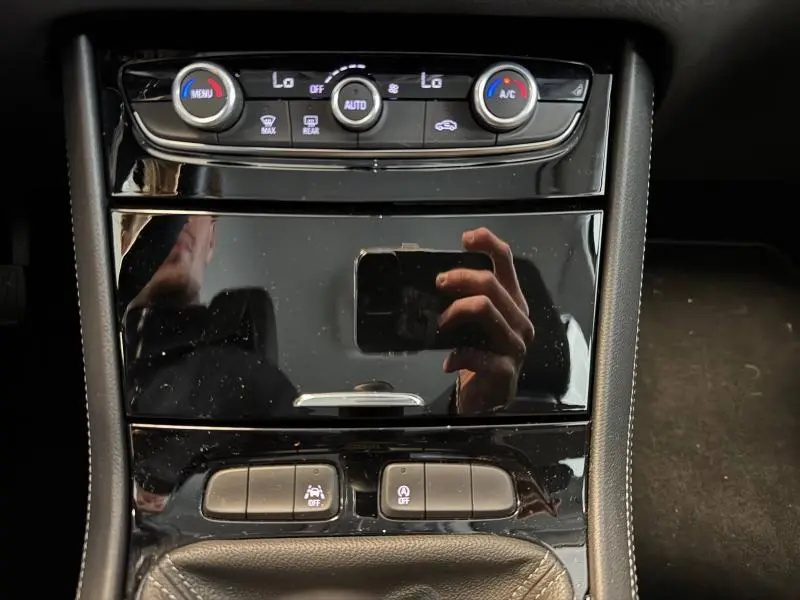 Vue rapprochée de la console centrale noire brillante de l'Opel Grandland 2023 avec commandes climatisation et boutons fonctionnels.