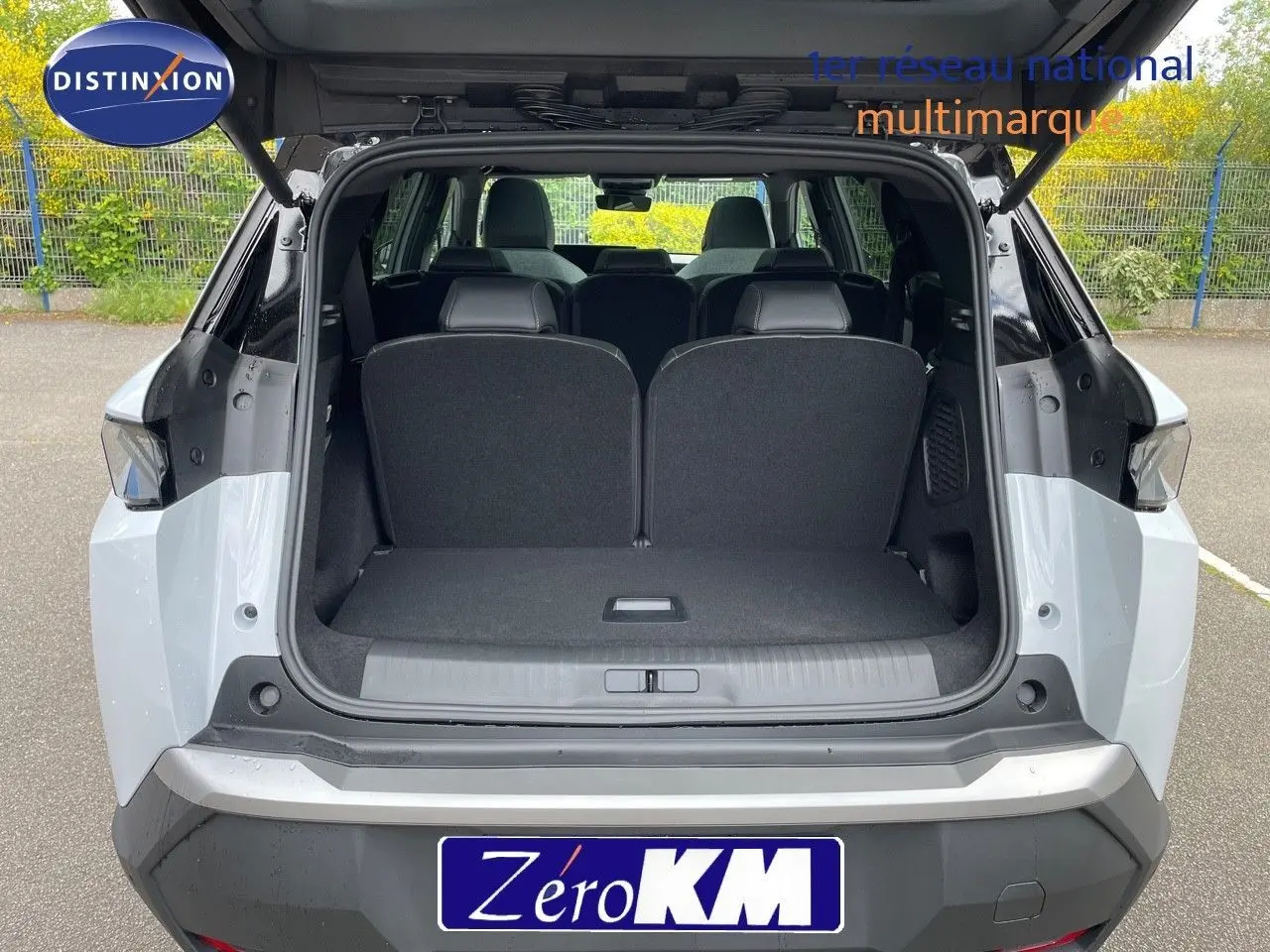 Vue arrière ouverte du Peugeot 5008 HYBRID 136CH GT blanc okenite avec toit noir, montrant le coffre spacieux.