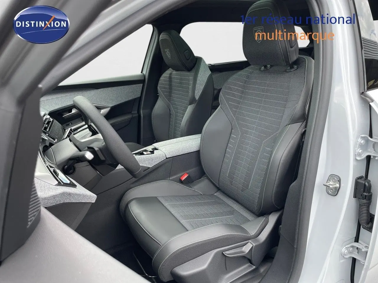 Vue intérieure côté conducteur du Peugeot 5008 Hybrid 136ch GT 2025 avec sièges mixtes tissu et cuir noir.