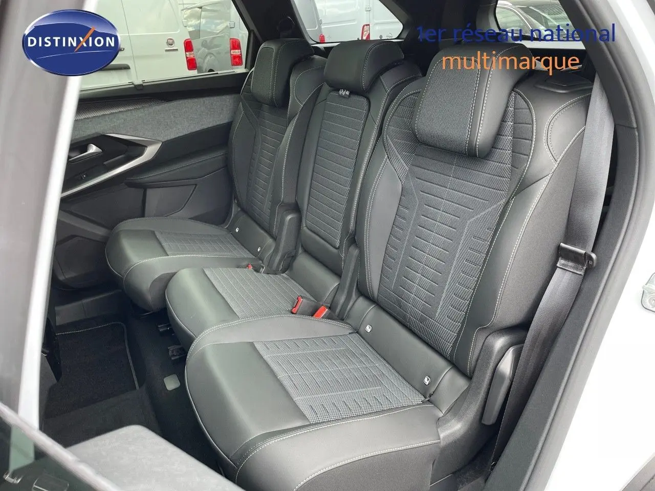 Vue intérieure des sièges arrière noirs en cuir et tissu du Peugeot 5008 Hybrid 2025, côté droit ouvert.