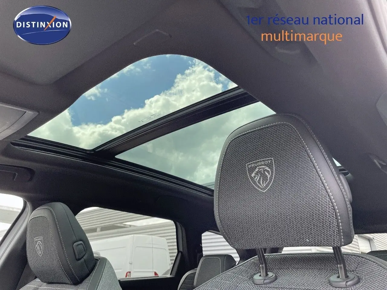 Vue intérieure du Peugeot 5008 Hybrid 136ch GT 2025, toit panoramique et appuie-tête avant en tissu noir brodé Peugeot.