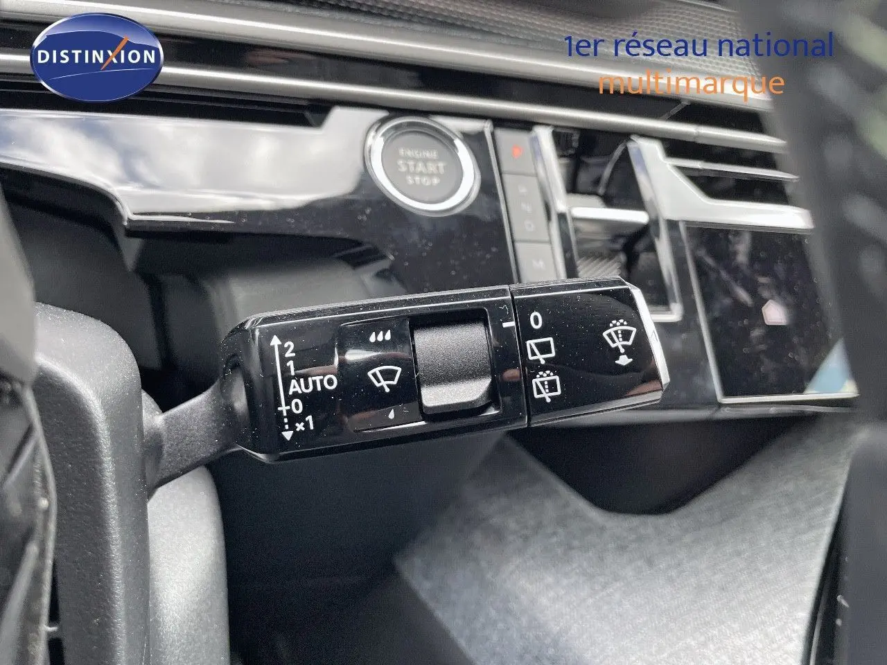 Gros plan sur la commande d'essuie-glace à gauche du volant dans l'habitacle du Peugeot 5008 Hybrid blanc 2025.
