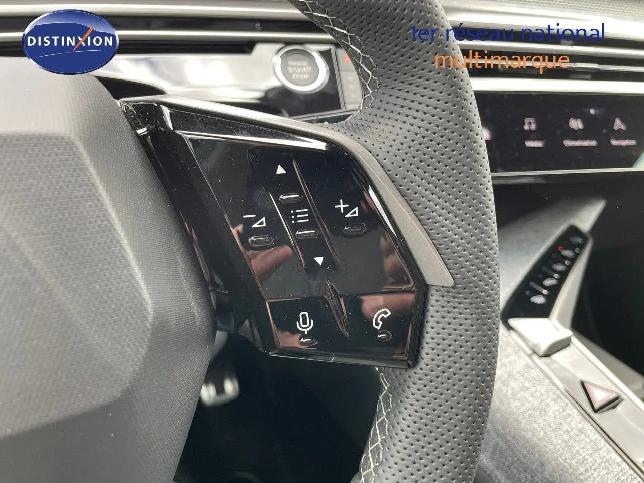 Gros plan sur le volant perforé et ses commandes tactiles du Peugeot 5008 Hybrid blanc Okenite avec toit noir, intérieur moderne.