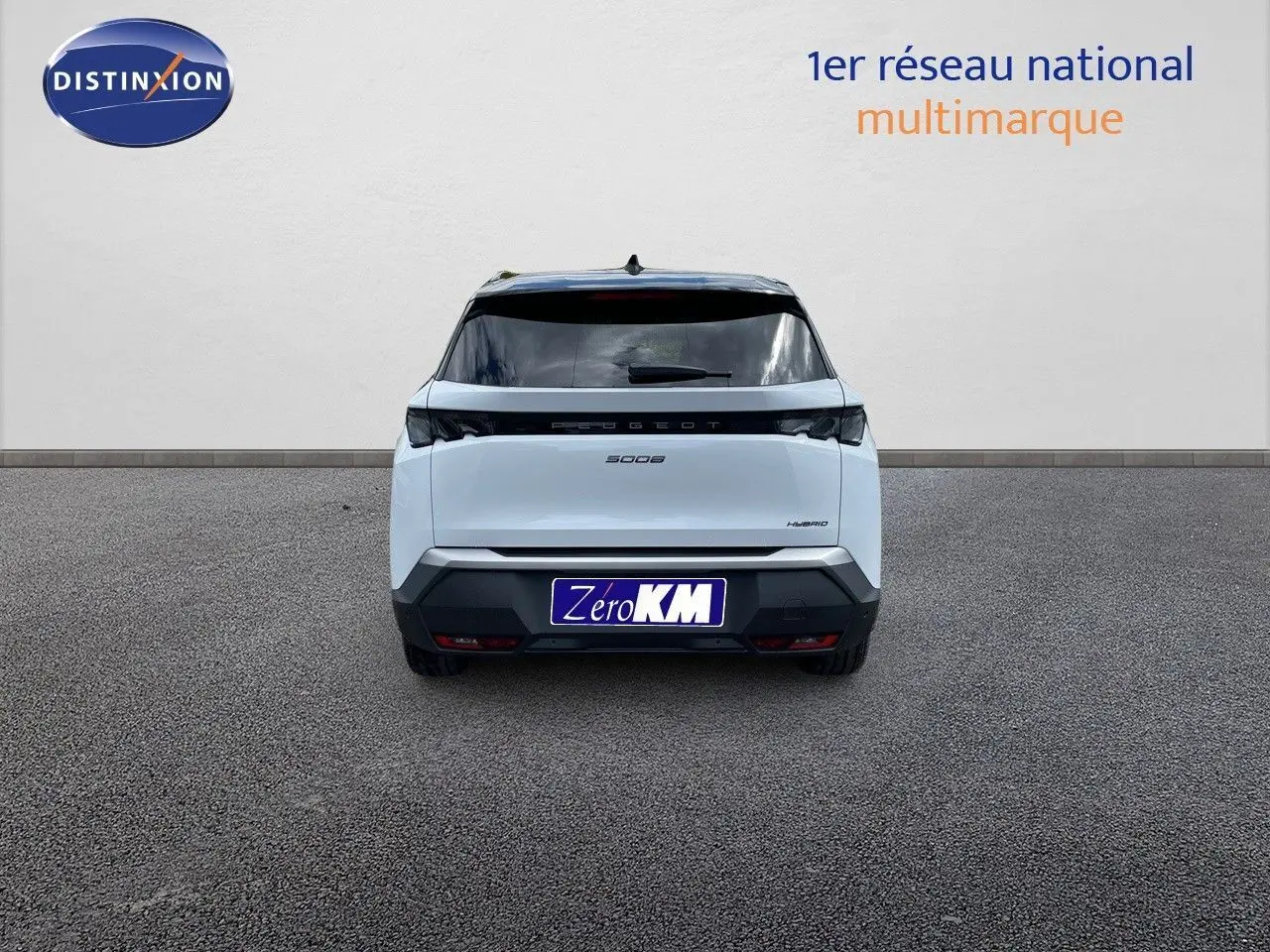 Vue arrière d'un Peugeot 5008 hybride blanc Okenite avec toit noir, immatriculé Zéro KM, sur sol gris.