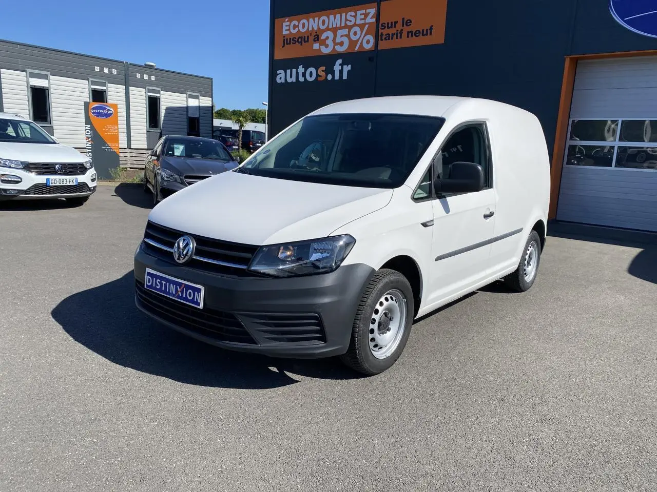 Volkswagen Caddy Van blanc candy vu en 3/4 avant droit avec pare-chocs noirs et jantes acier simples.