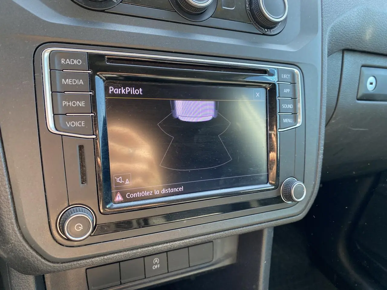 Gros plan sur l'écran central du Volkswagen Caddy 2020 montrant l'alerte ParkPilot avec commandes autour.