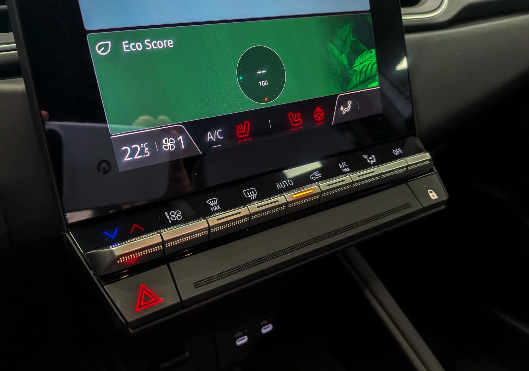 Gros plan sur la console centrale du Renault Captur 2025, affichant la climatisation et les commandes tactiles rétroéclairées.