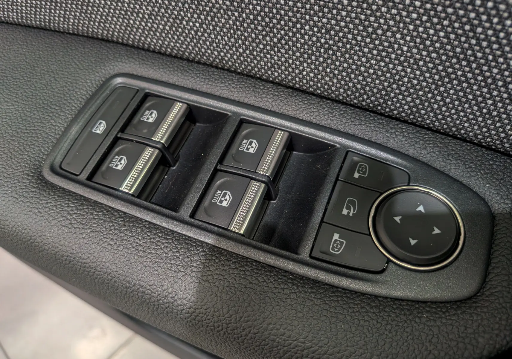 Panneau de commandes des vitres électriques et rétroviseurs sur la porte côté gauche du Renault Captur Gris Rafale 2025.