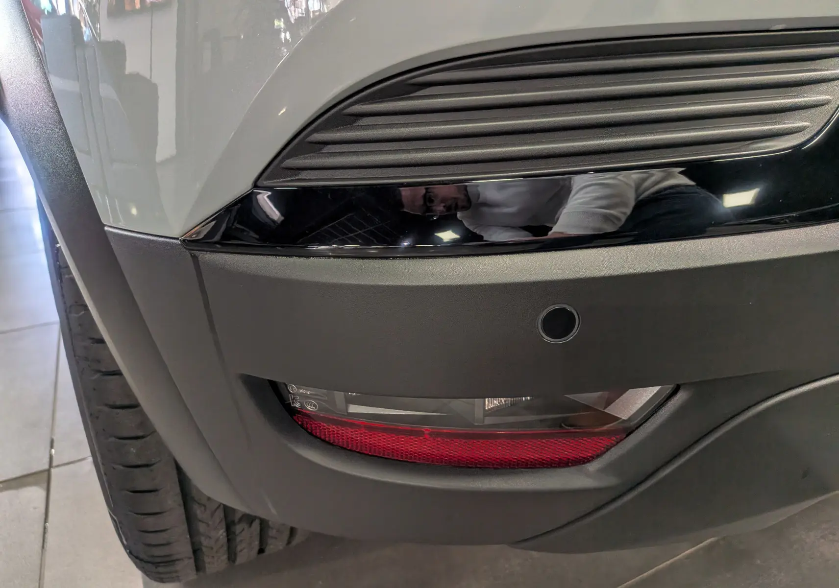 Gros plan sur le feu arrière et le pare-chocs avant gris du Renault Captur Mild Hybrid 2025, avec détails noirs brillants.