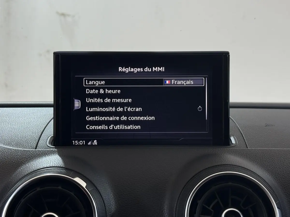 Écran central du système MMI affichant les réglages, avec tableau de bord noir de l'Audi A3 2.0 TDI 2018.