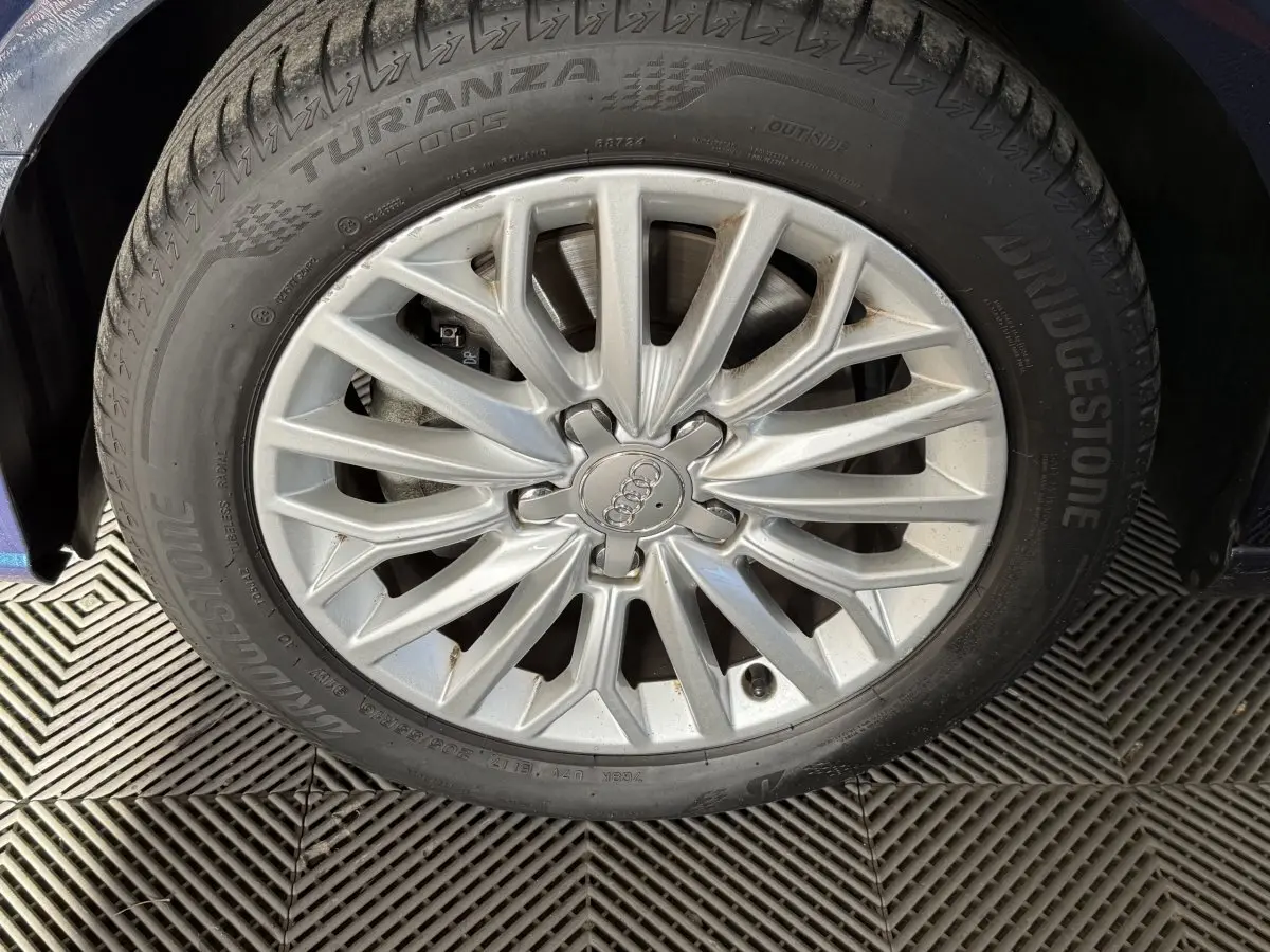 Gros plan sur la jante argentée et le pneu Bridgestone Turanza d'une Audi A3 bleu, côté avant gauche.