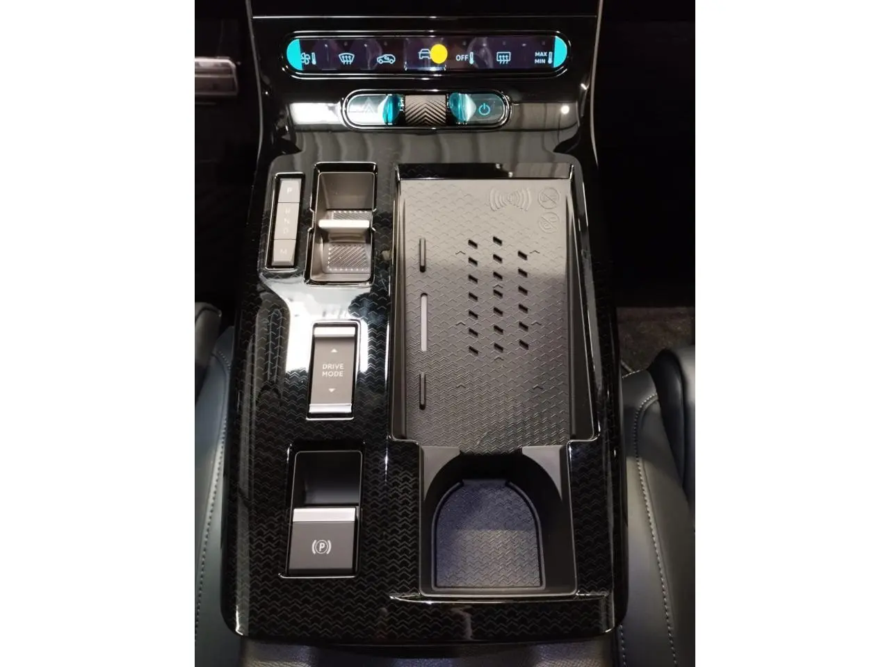 Vue plongeante sur la console centrale noire brillante du Citroën C5 Aircross 2026 avec commandes et chargeur sans fil.