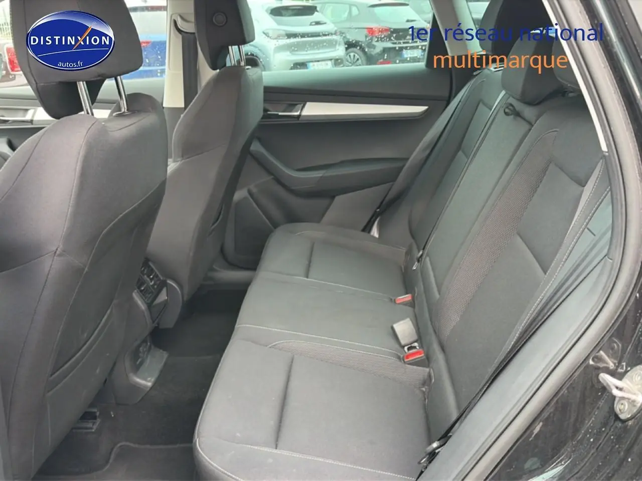 Vue intérieure côté droit montrant la banquette arrière noire du Skoda Karoq 2025, avec portes ouvertes.