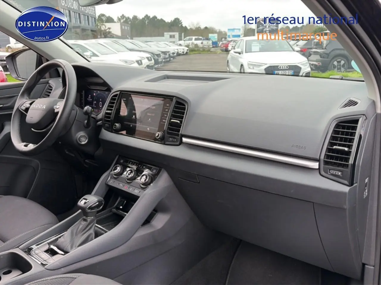Vue intérieure côté passager du Skoda Karoq noir 2025, montrant tableau de bord et console centrale moderne.