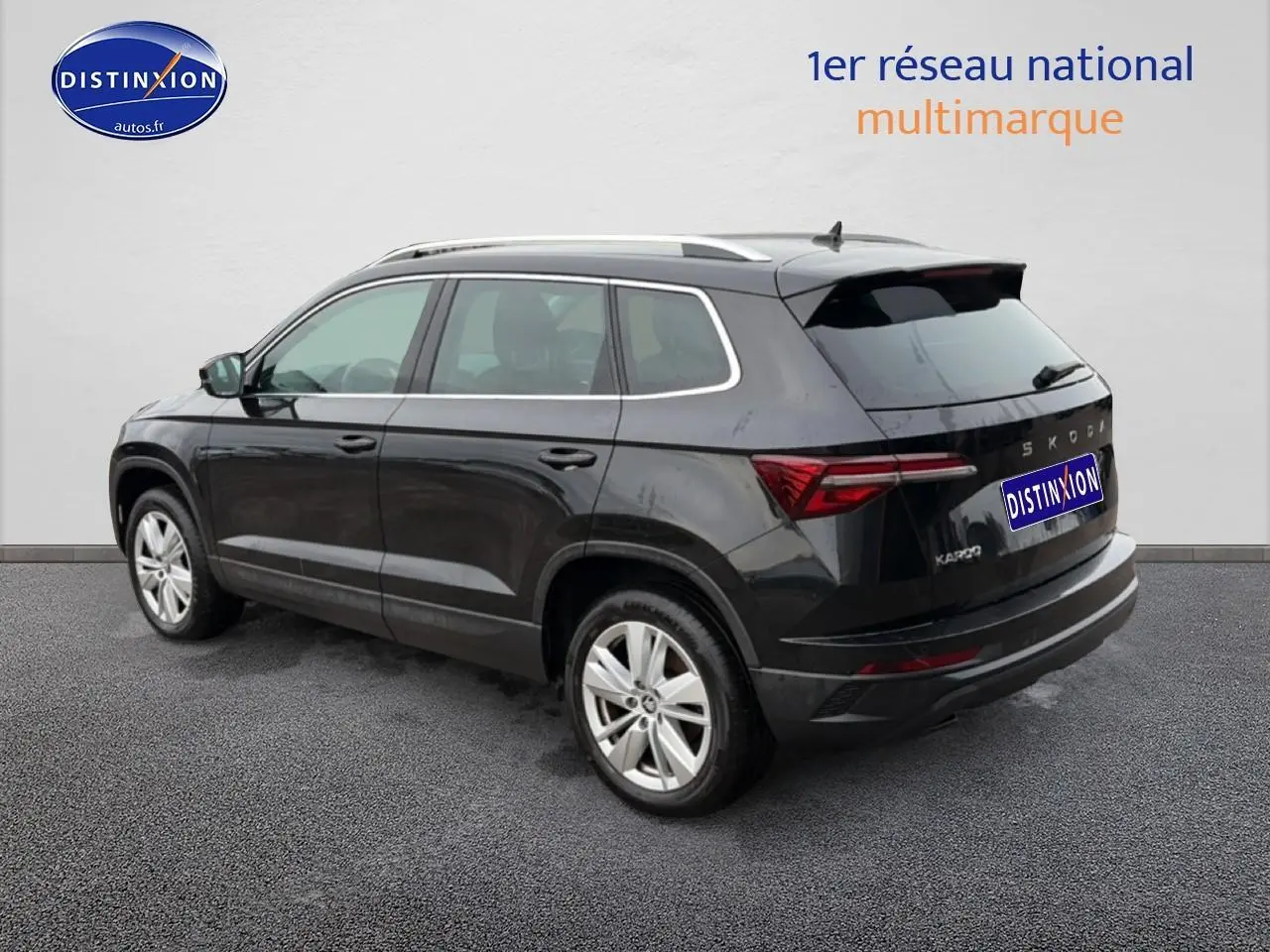 Vue 3/4 arrière droite d'un Skoda Karoq noir 2025 avec barres de toit et feux arrière LED distinctifs.