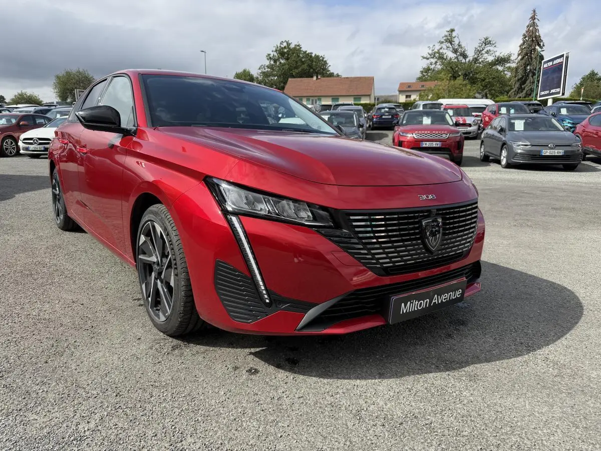 Peugeot 308 SW rouge Elixir vue 3/4 avant droit, calandre noire avec logo lion et phares LED distinctifs.