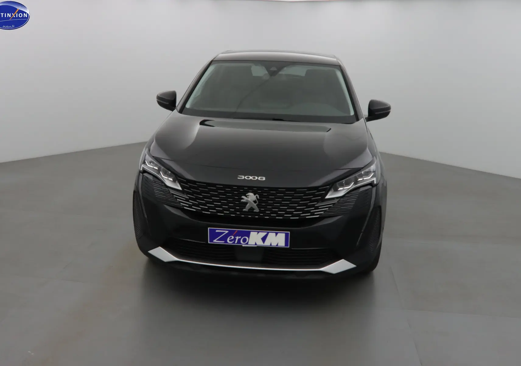 Peugeot 3008 noir perle métal vue de face dans un studio, avec calandre distinctive et phares LED allumés.