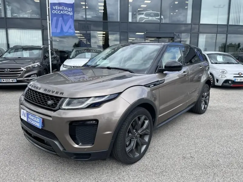 Range Rover Evoque marron métal vu en 3/4 avant droit, avec jantes foncées et calandre noire distinctive.