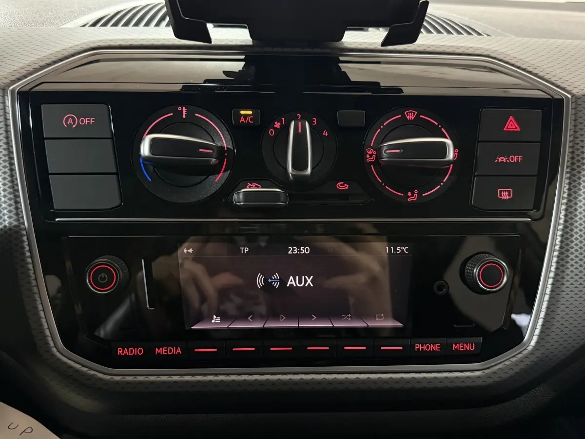 Vue rapprochée du tableau de bord noir du Volkswagen Up 1.0 65 Active 2022, avec commandes climatisation et écran multimédia.