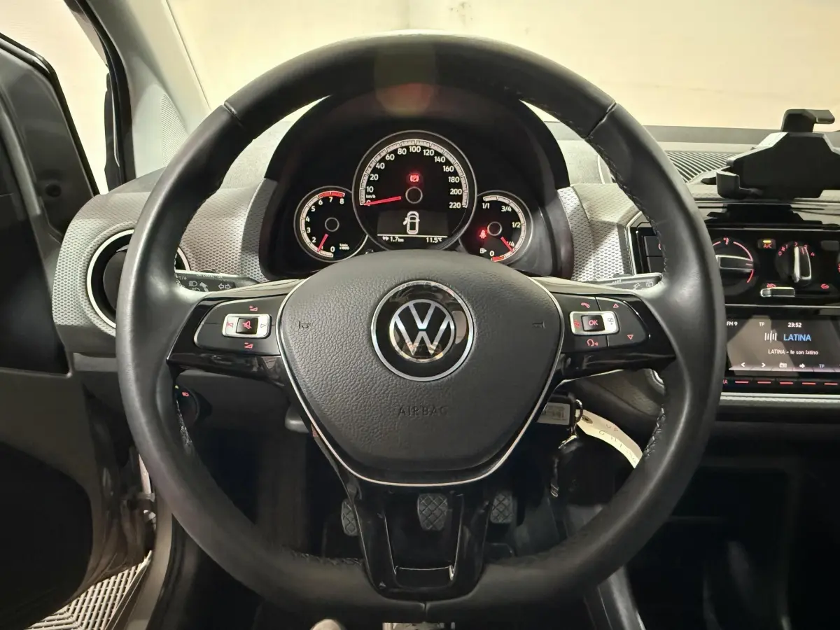 Vue intérieure centrée sur le volant cuir noir du Volkswagen Up 1.0 65 Active avec tableau de bord et commandes visibles.