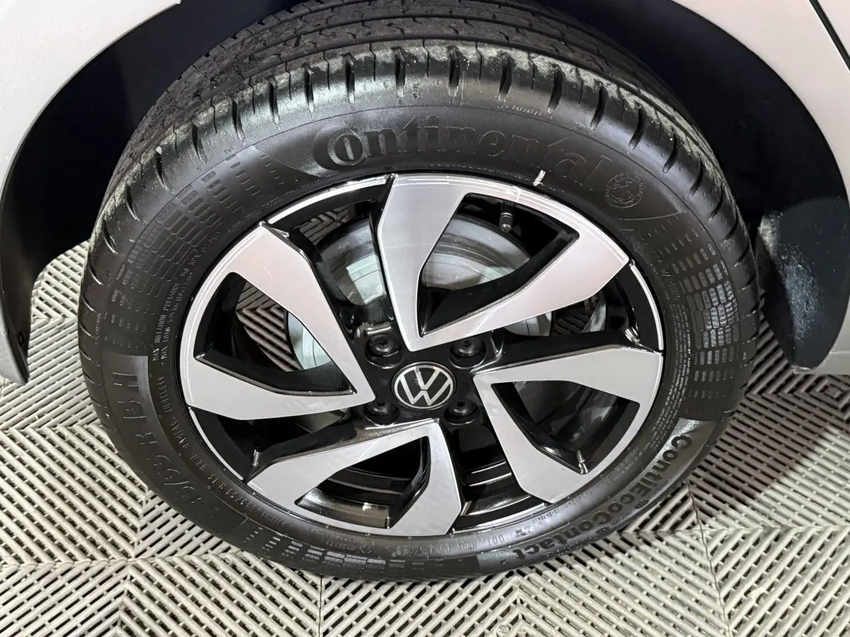 Gros plan sur la jante alliage bicolore noire et argentée d'une Volkswagen Up gris foncé, vue côté droit.