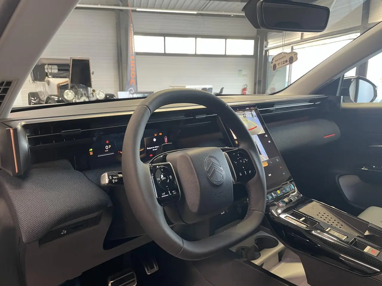 Vue intérieure du tableau de bord et volant noir du Citroën C5 Aircross 2026 avec écran tactile vertical et finitions noires brillantes.