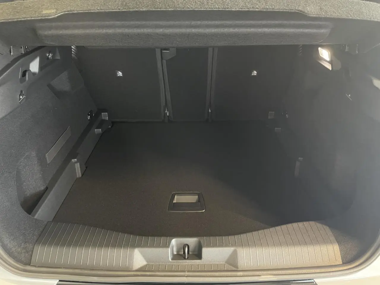 Coffre ouvert vu de l'arrière du Citroën C5 Aircross blanc avec intérieur noir et espace de rangement vide.