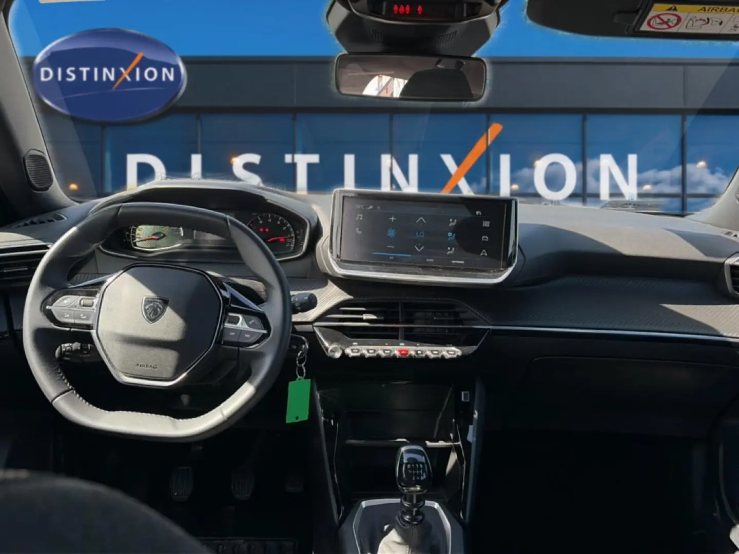 Vue intérieure avant du Peugeot 2008 gris 2025, avec tableau de bord moderne et écran tactile central.