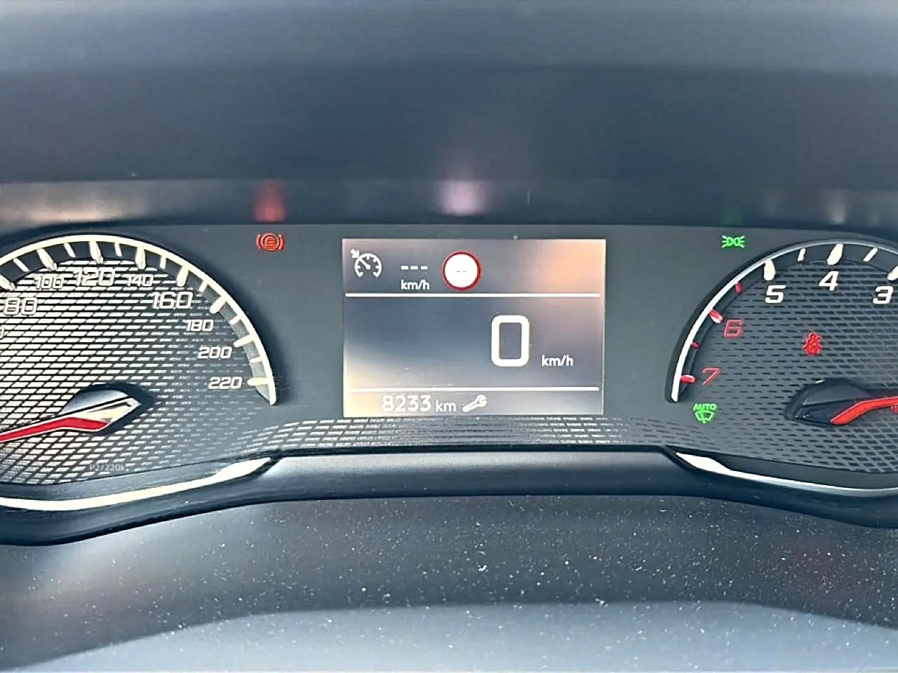 Vue rapprochée du tableau de bord numérique du Peugeot 2008 1.2 100 style, affichant 8233 km et compte-tours.