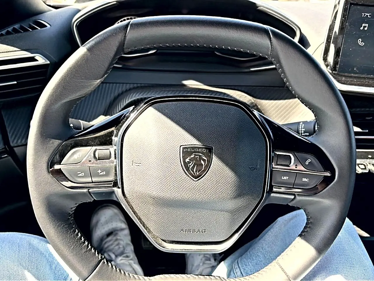 Vue rapprochée du volant noir multifonction de la Peugeot 2008 2025 avec logo lion au centre et commandes intégrées.