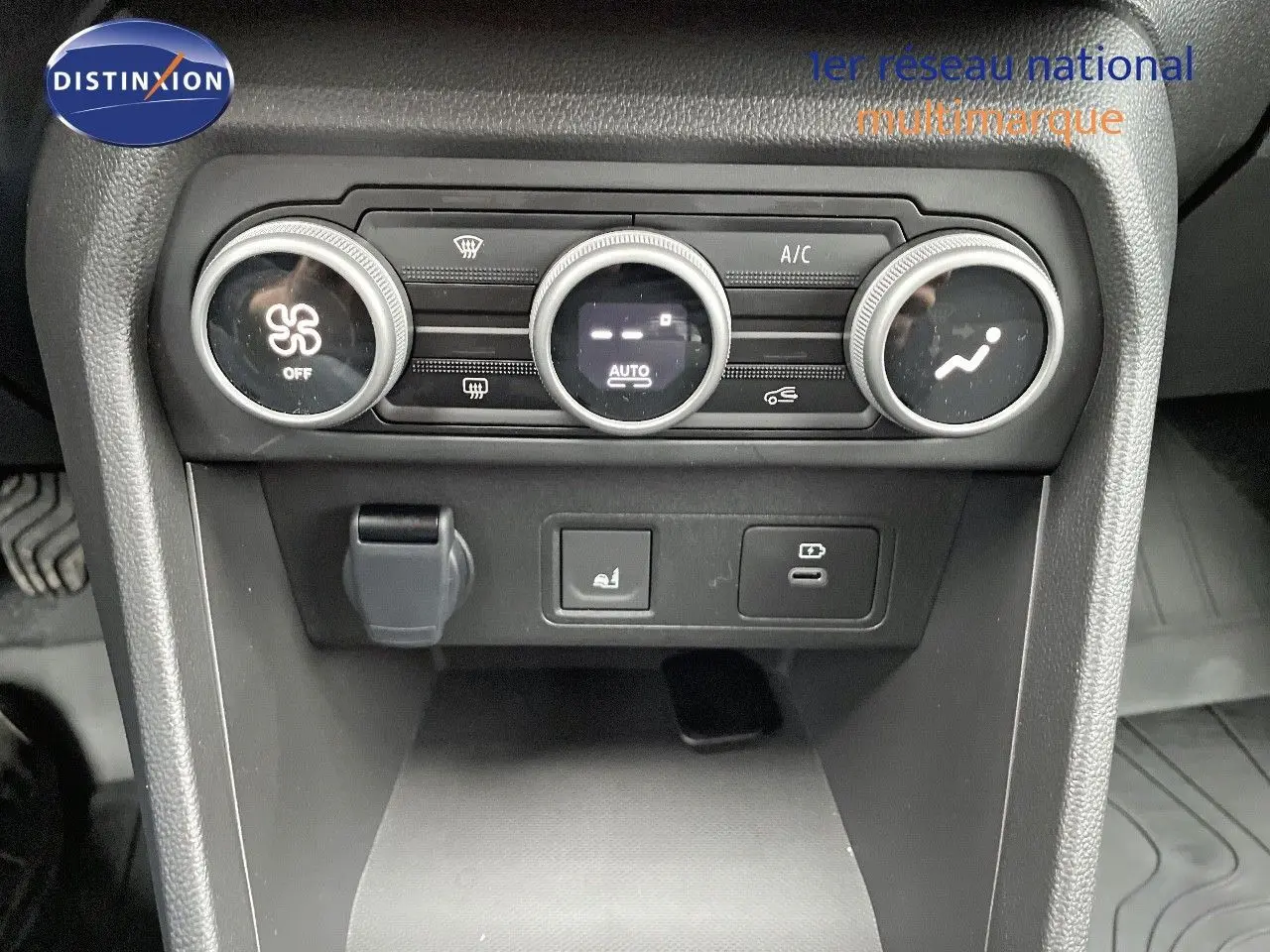 Vue rapprochée du tableau de bord central du Dacia Jogger noir nacré, montrant les commandes de climatisation et prises USB.
