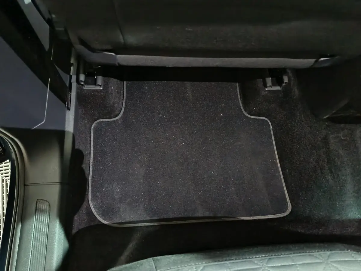 Vue rapprochée du tapis de sol noir côté arrière droit du Volkswagen Tiguan bleu 2021, intérieur propre et soigné.