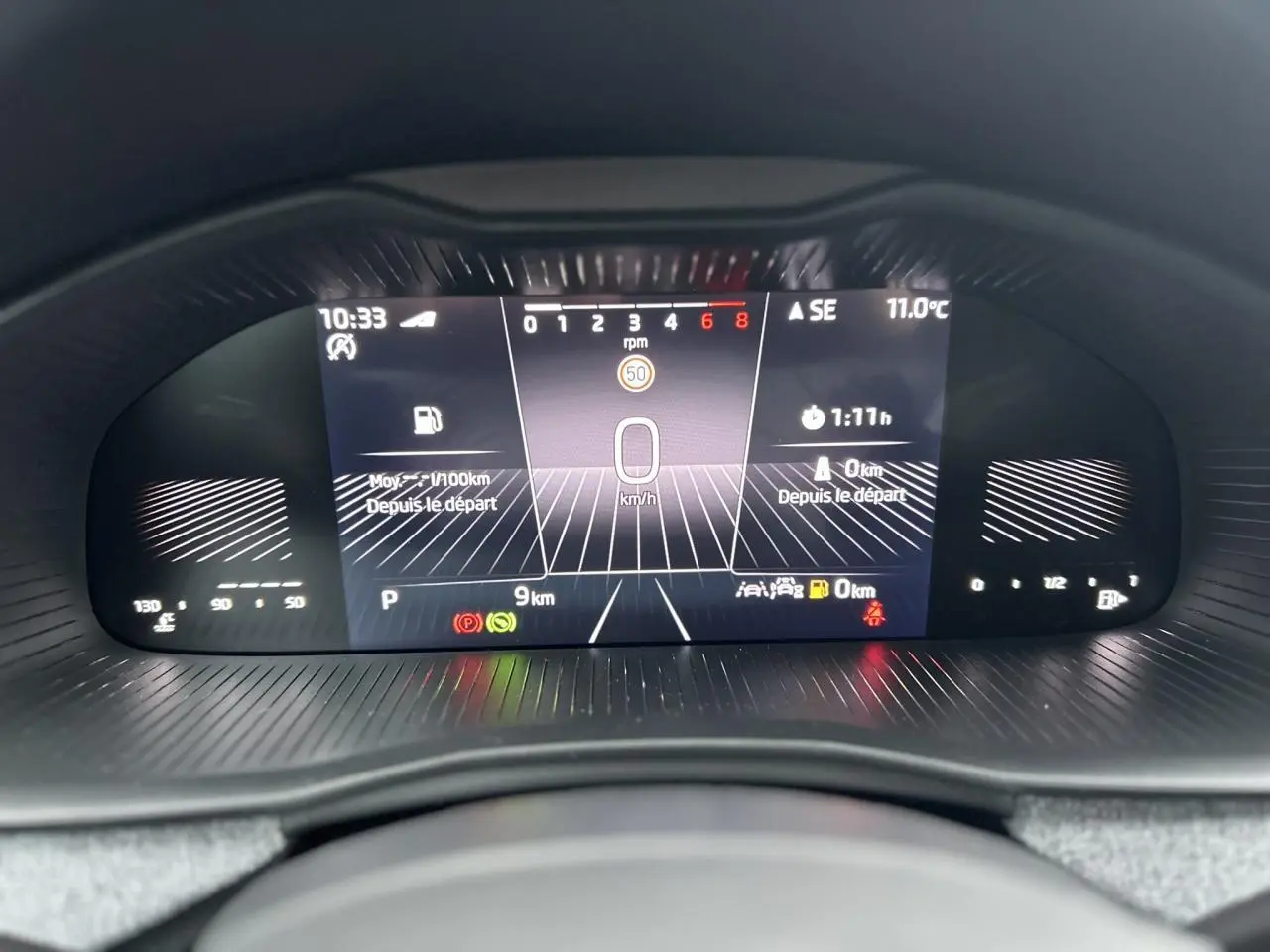 Affichage numérique du tableau de bord du Skoda Kamiq TSI 116 DSG7, vue frontale centrée, fond noir avec informations de conduite.