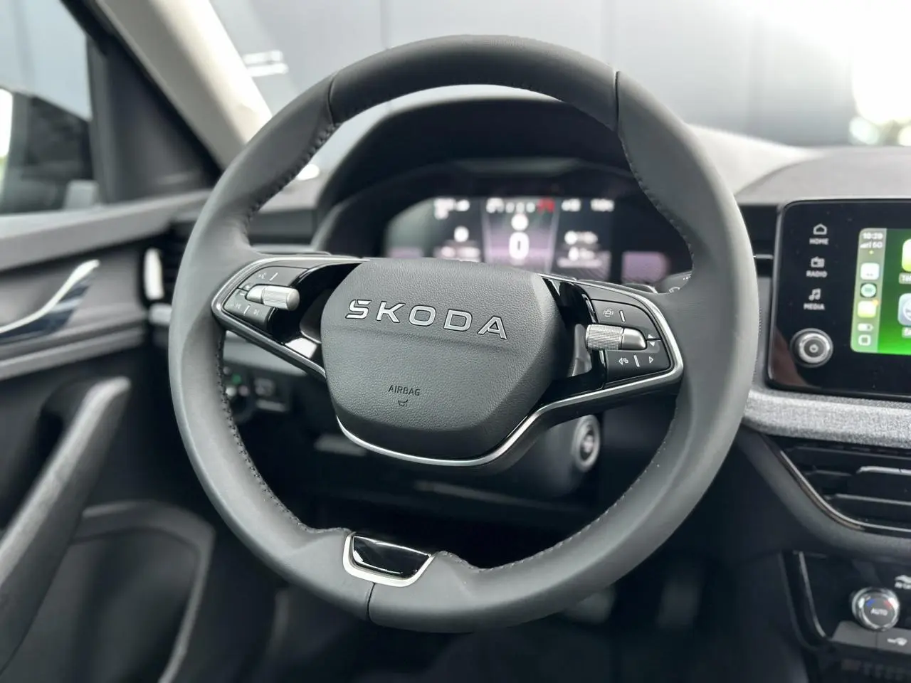 Volant cuir multifonctions SKODA KAMIQ 2025 vu de face avec tableau de bord digital et écran tactile Apple Car Play.