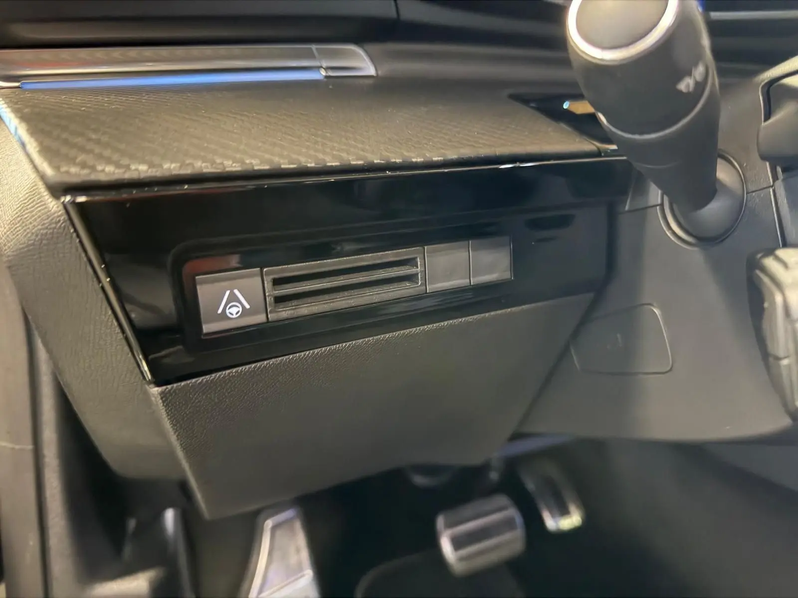 Détail intérieur côté conducteur du tableau de bord noir brillant avec commande d’aide au maintien dans la file Peugeot 508 SW 2024.