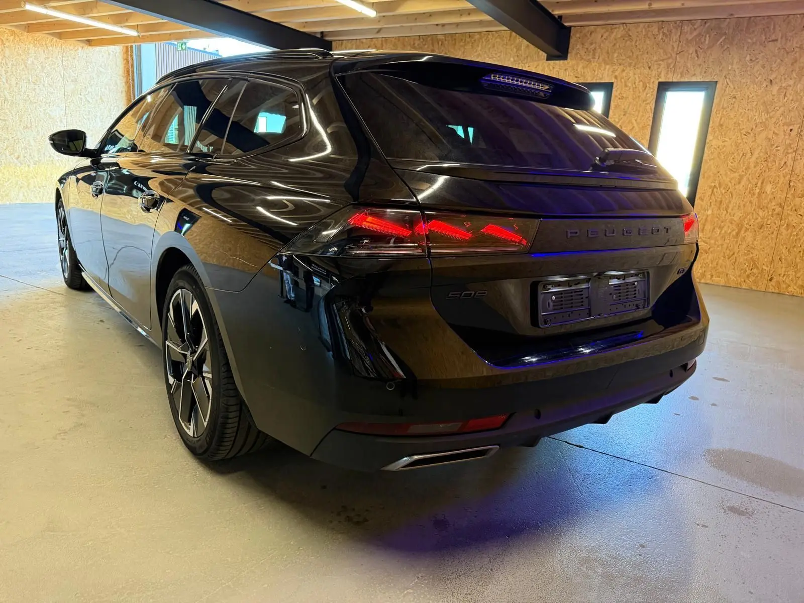 Peugeot 508 SW noire vue 3/4 arrière droit, avec feux arrière LED et jantes alliage 18 pouces bi-ton.