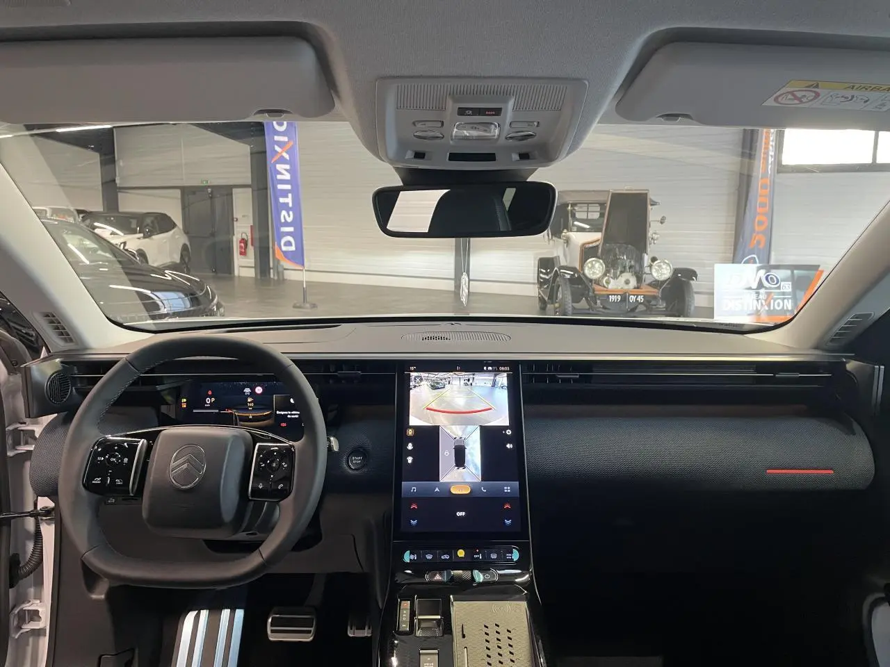 Vue intérieure frontale du tableau de bord du Citroën C5 Aircross 2026 avec écran tactile vertical et volant multifonctions noir.