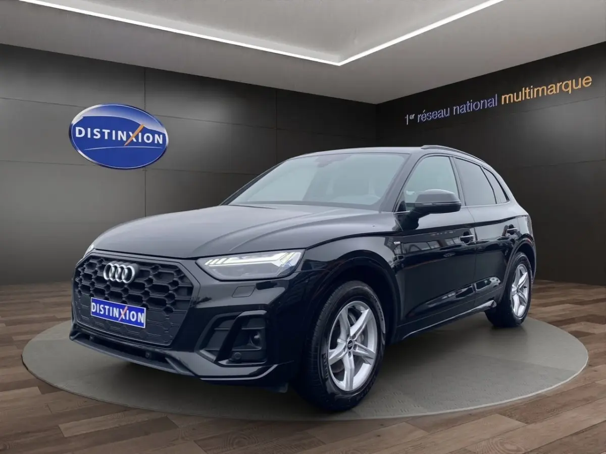 Audi Q5 noir en vue 3/4 avant droit, avec calandre hexagonale noire et jantes argentées cinq branches.