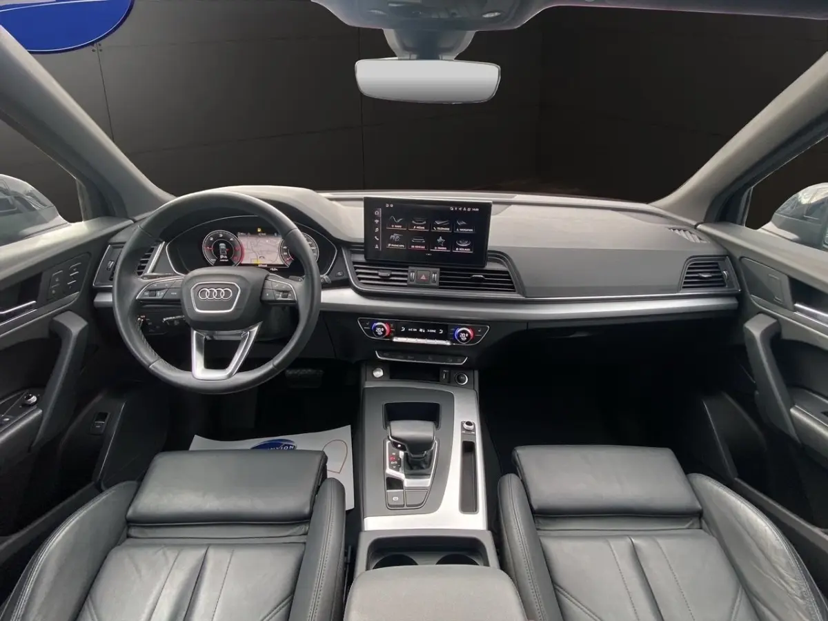 Vue intérieure avant de l'Audi Q5 noir, avec tableau de bord moderne et écran tactile central.