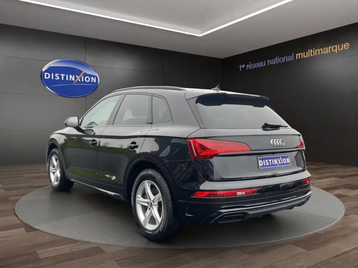Audi Q5 35 TDI S Line noir en 3/4 arrière droit, avec feux LED et jantes alliage visibles en showroom.