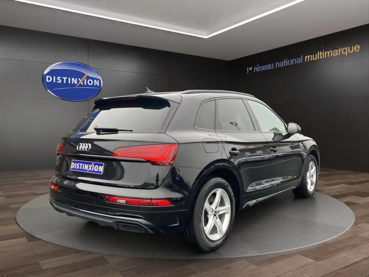 Audi Q5 noir vue 3/4 arrière droit, avec feux LED et jantes alliage cinq branches visibles.