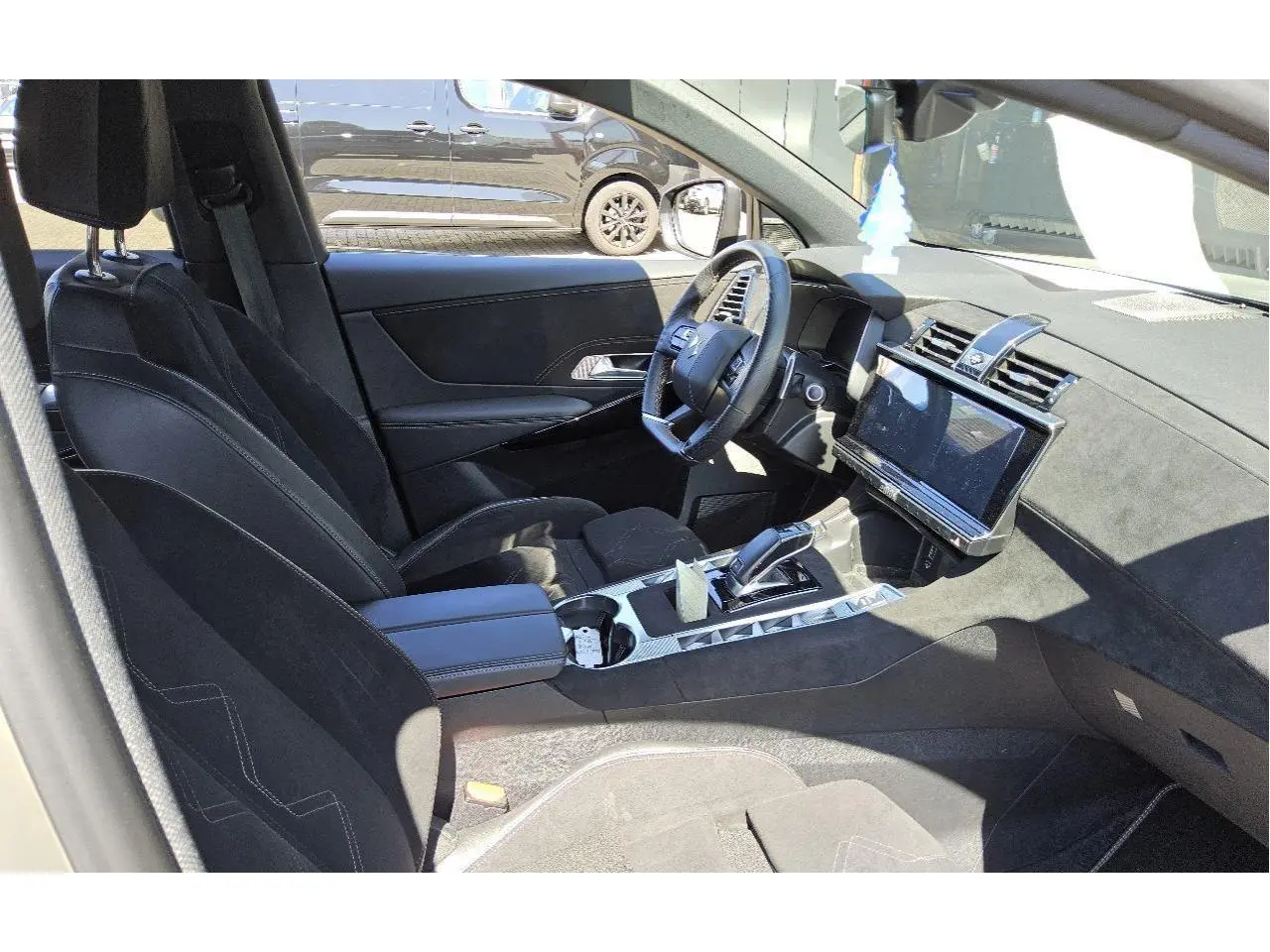 Vue intérieure côté conducteur du DS7 2024 avec sellerie Alcantara noire et console centrale moderne.