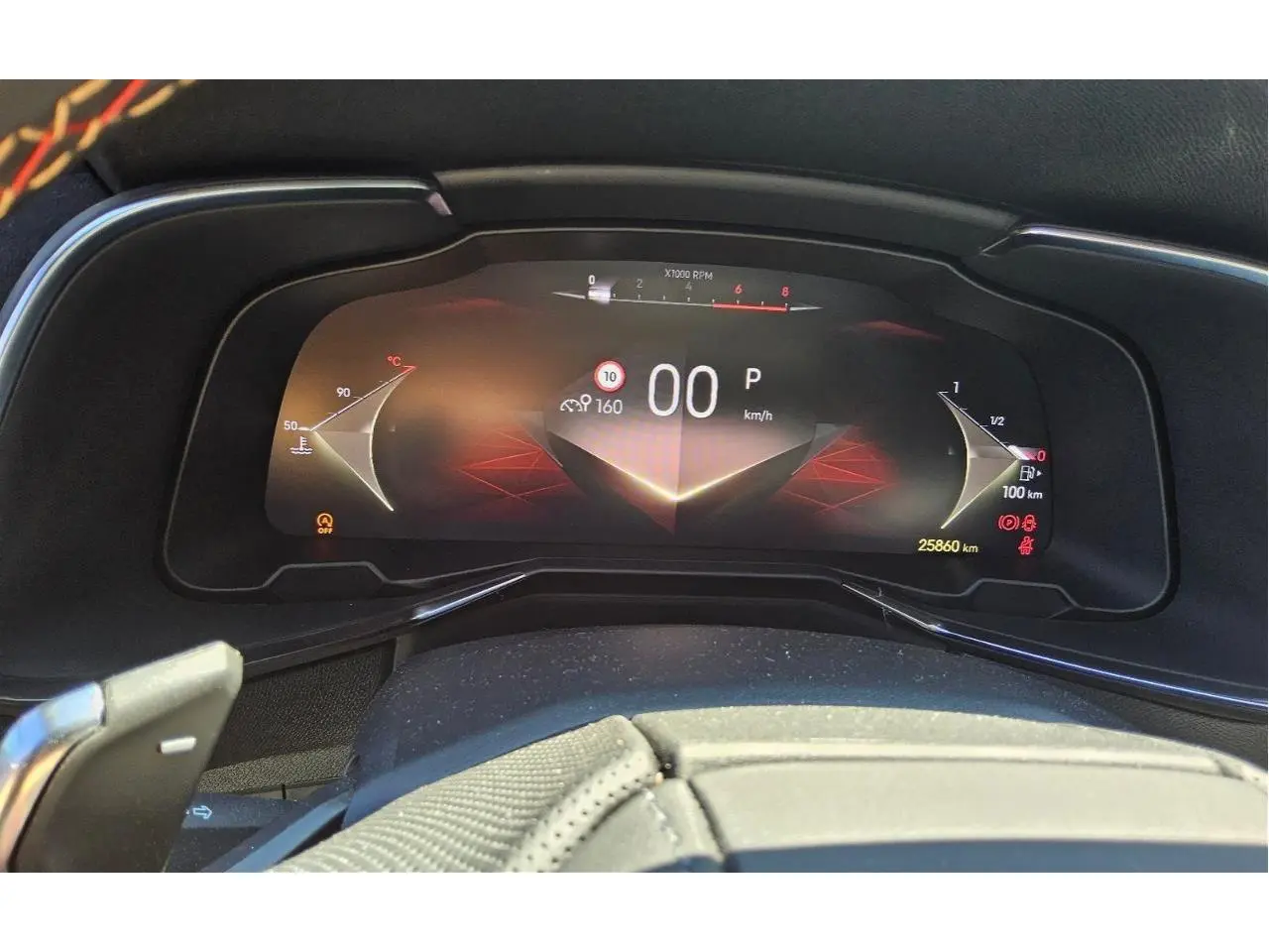 Tableau de bord numérique du DS7 2024 affichant la vitesse à 0 km/h, avec détails lumineux rouges et noirs.