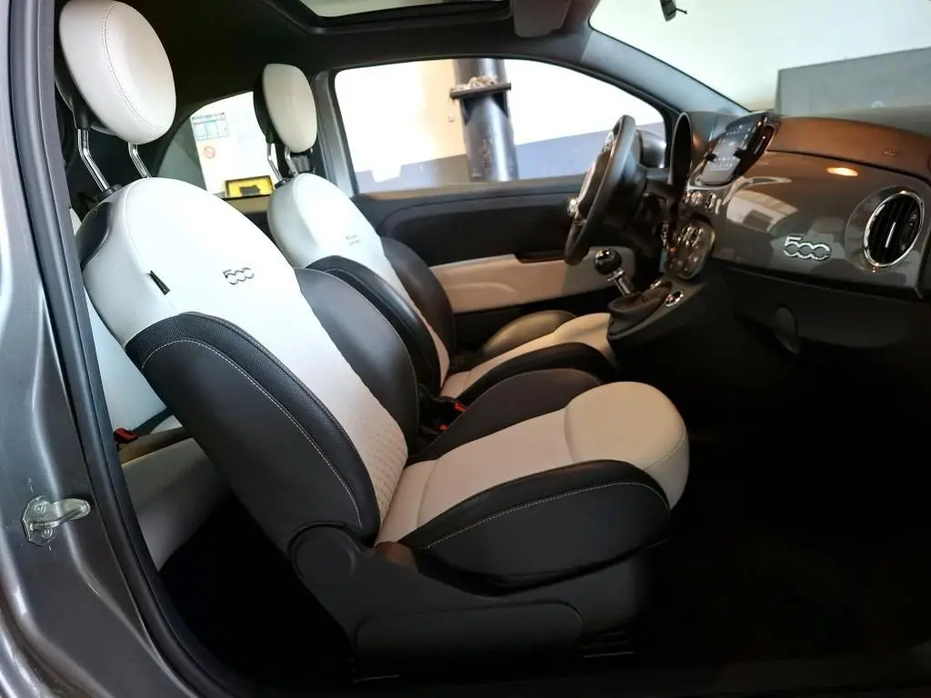 Vue intérieure côté gauche de la FIAT 500 2022 gris Electroclash, sièges bicolores noirs et blancs avec logo 500 brodé.