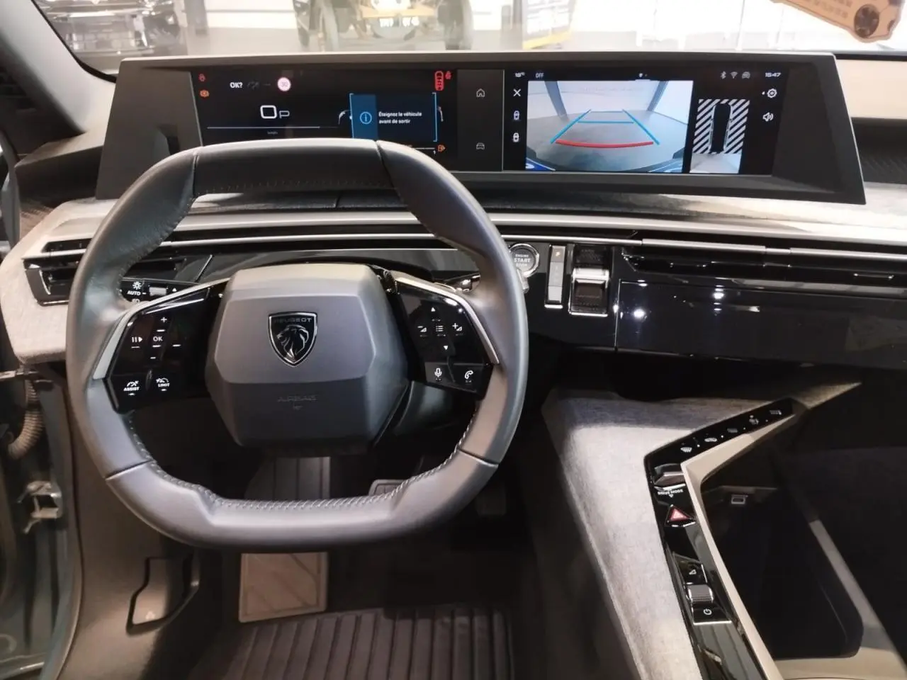 Vue intérieure du poste de conduite du Peugeot 5008 2025, volant compact et double écran HD panoramique.