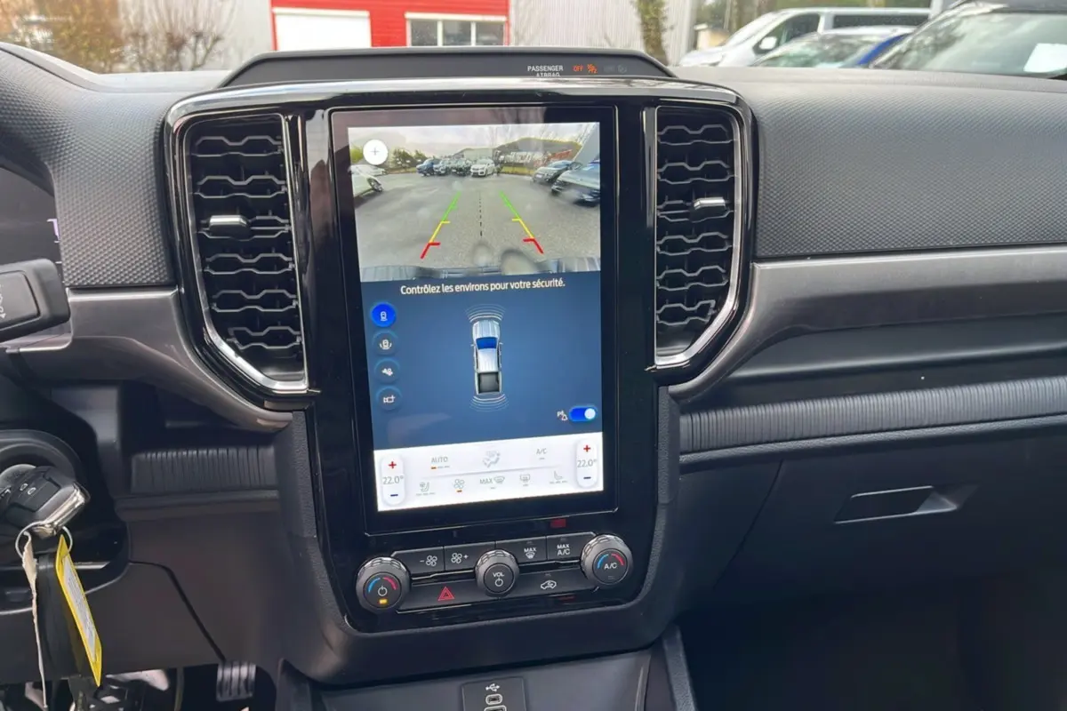 Vue intérieure du tableau de bord noir du Ford Ranger 2025 avec écran tactile central affichant la caméra de recul.