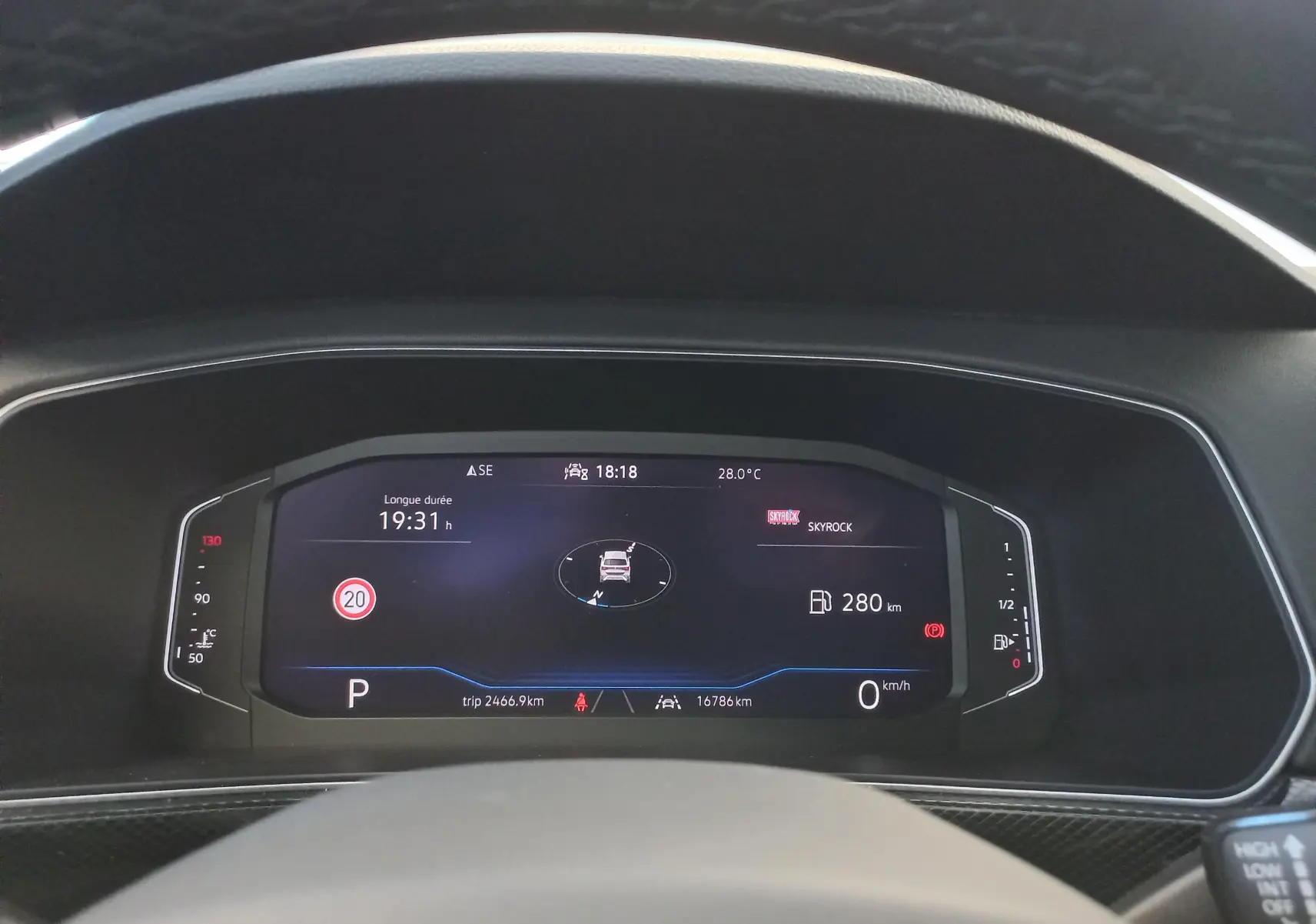 Tableau de bord numérique du Volkswagen T-Cross 2025 affichant la vitesse, autonomie et température, vue depuis le siège conducteur.