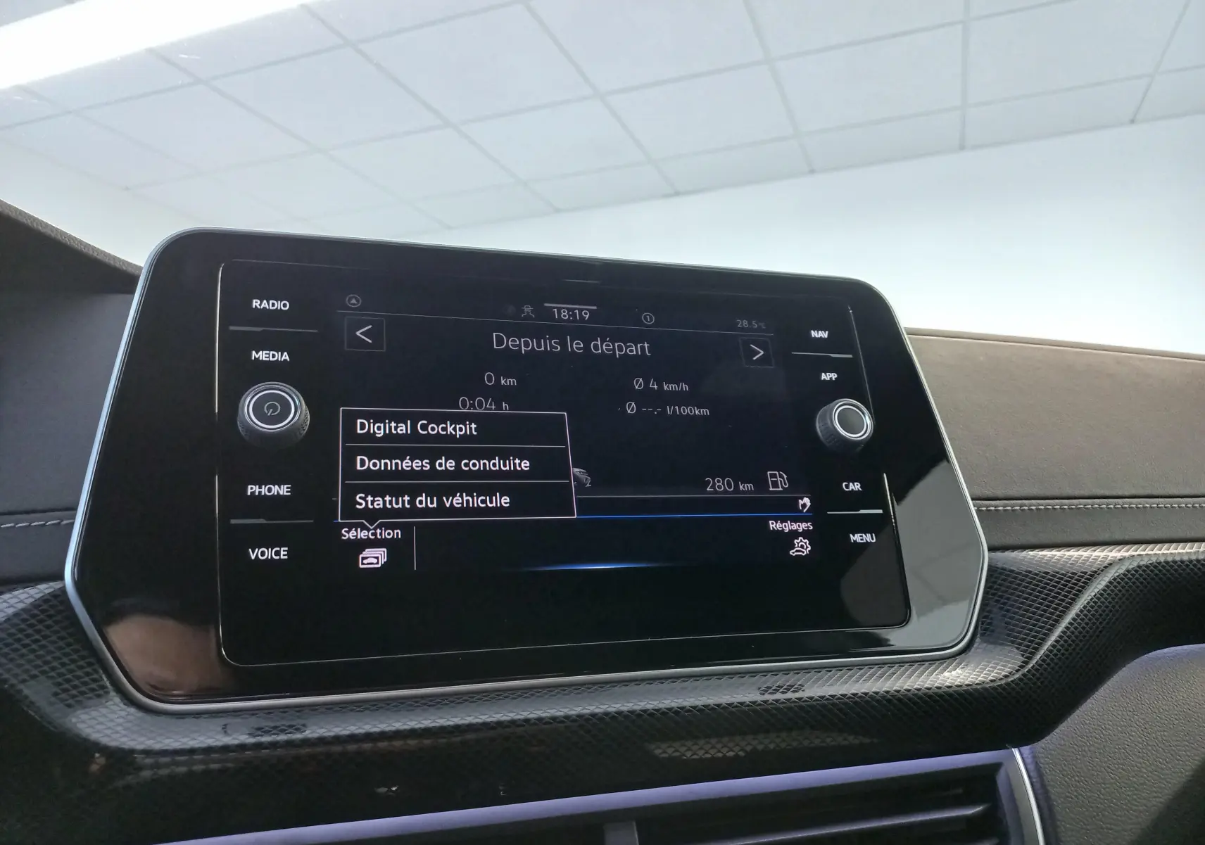 Écran tactile central du Volkswagen T-Cross 2025 affichant le menu Digital Cockpit, avec finition carbone autour.